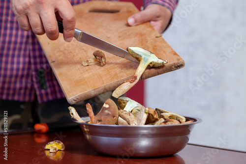 Hands pour half sliced mushrooms into plate..