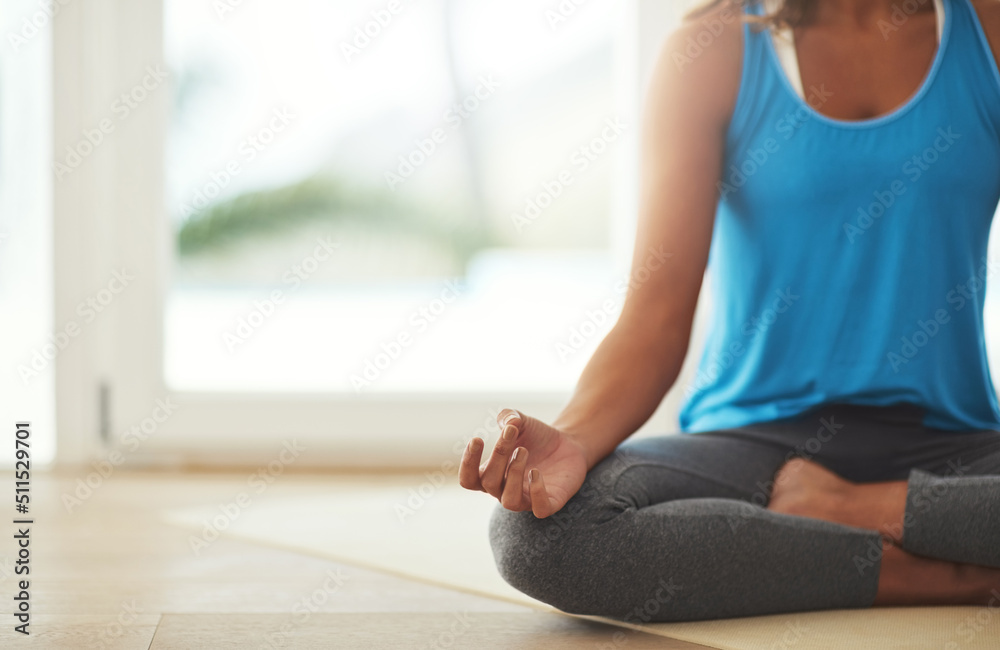 The art of meditation. Cropped shot of a young woman practicing the art of meditation at home.