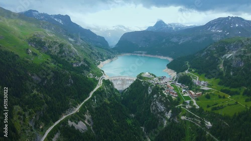Water dam and reservoir lake aerial drone footage in French Alps mountains generating hydroelectricity. Low CO2 footprint, decarbonize, renewable energy, sustainable development. 4K 60fps video. photo