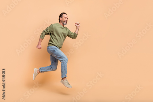 Full body profile photo of energetic excited person look empty space run fast isolated on beige color background