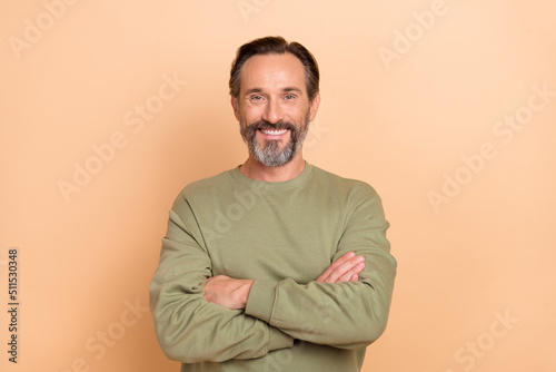 Portrait of attractive cheerful man folded arms wearing cozy sweater isolated over beige pastel color background