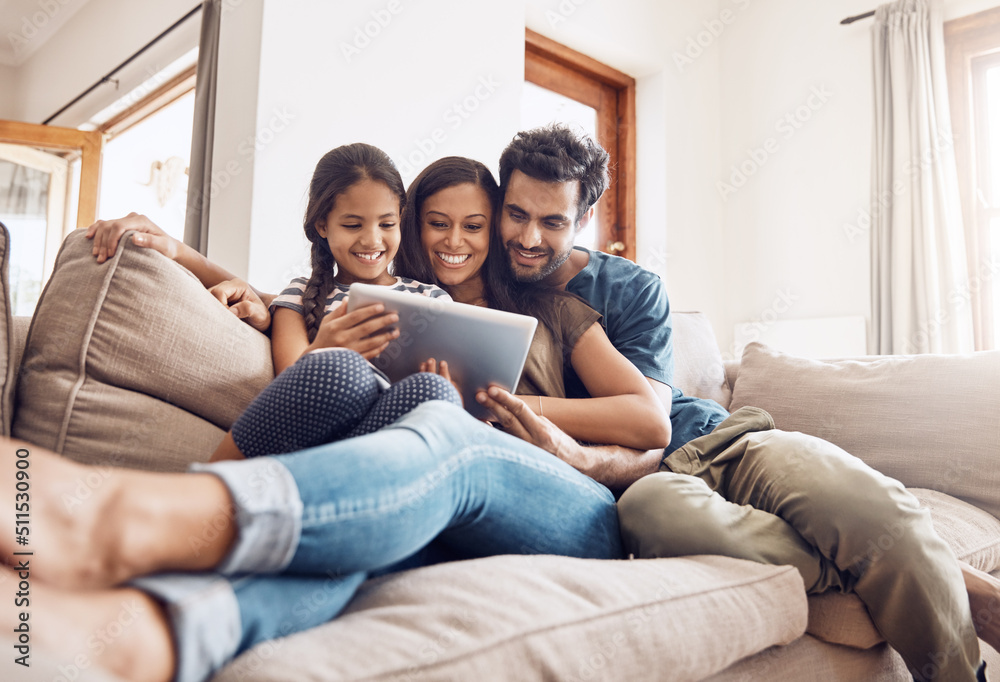 Making screen time bonding time. Shot of a mother and father using a digital tablet with their daughter on the sofa at home. Making screen time bonding time. Shot of a mother and father using a digital tablet with their daughter on the sofa at home.