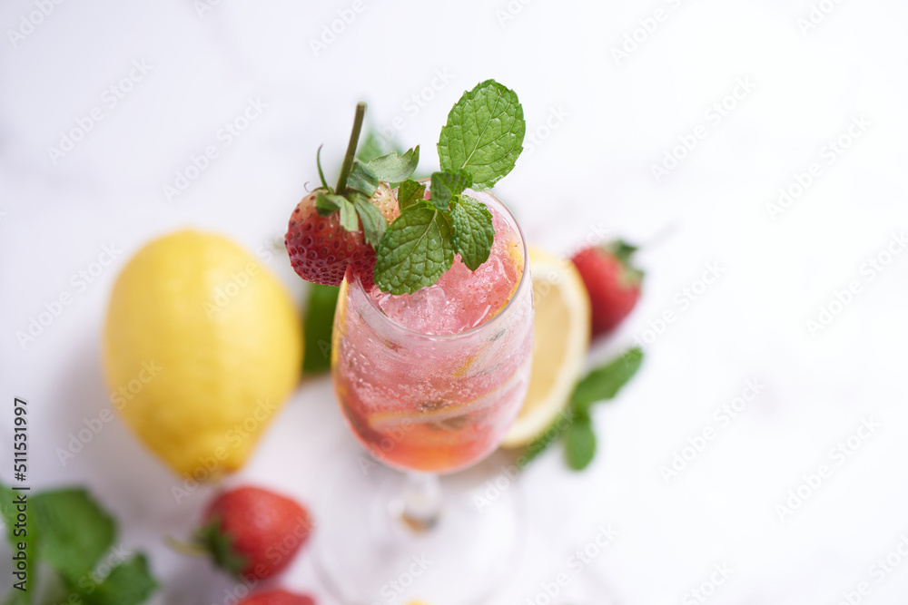 Lemon and strawberry lemonade mint fresh homemade in glass, Summer cold cocktail, Strawberry lemon lime mojito, light background, copy space, A refreshing summer drink concept. Lemon and strawberry lemonade mint fresh homemade in glass, Summer cold cocktail, Strawberry lemon lime mojito, light background, copy space, A refreshing summer drink concept.