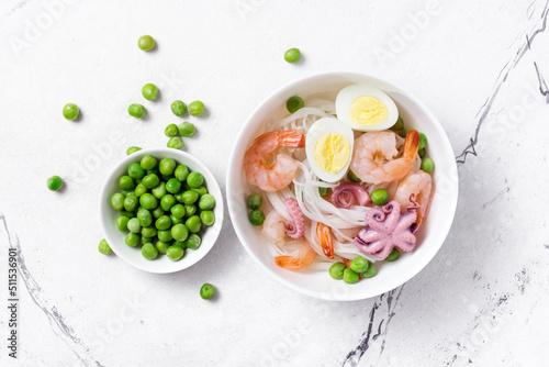 A traditional dish of Asian cuisine. Rice vermicelli with shrimps, bebe octopus and green peas