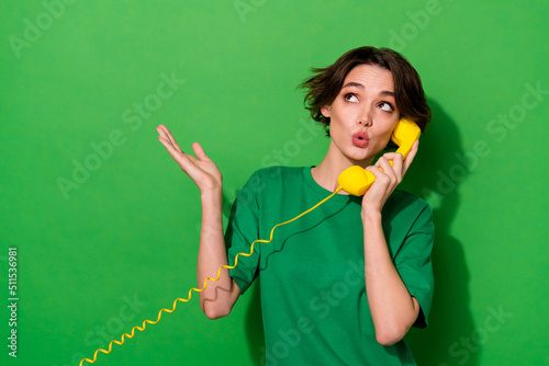 Photo of pretty dreamy lady wear spring outfit looking empty space talking phone isolated green color background