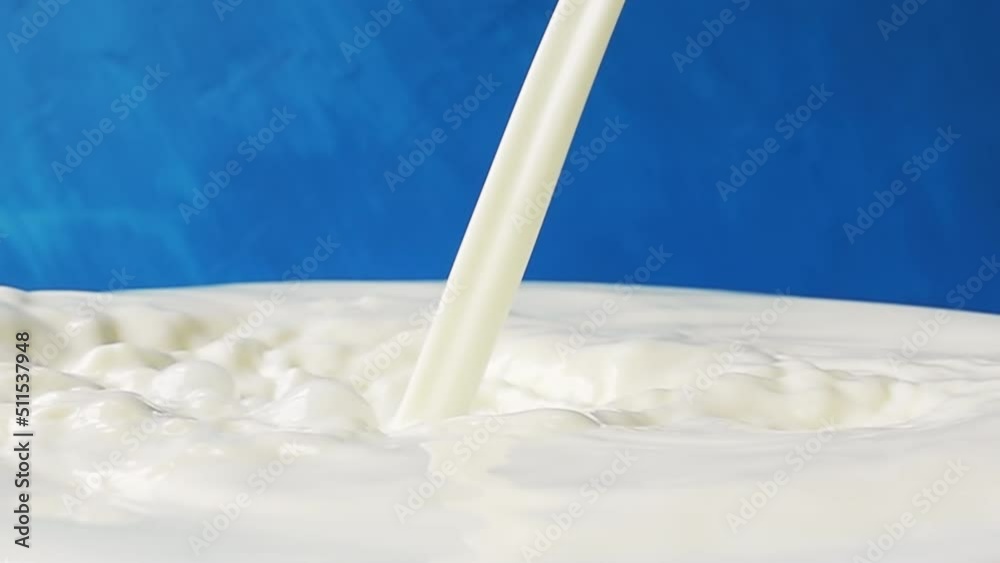 Milk pours on the surface of milk close-up with beautiful splashes and drops on a blue background. 4k raw slow motion video 60 fps. Filmed on high speed cinema camera, 1000fps. Milk pours on the surface of milk close-up with beautiful splashes and drops on a blue background. 4k raw slow motion video 60 fps. Filmed on high speed cinema camera, 1000fps.