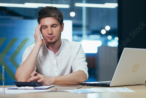 Businessman in the office thinking in the office, working with documents and calculating reports on a calculator