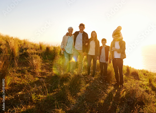Theyre happiest when theyre all together. A portrait of a happy family standing on a grassy hill at sunset.