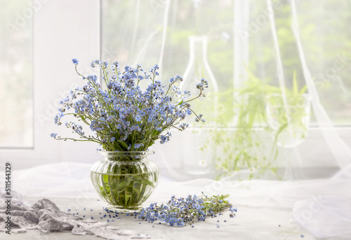 Bouquet of forget-me-nots in a vase on a white windowsill