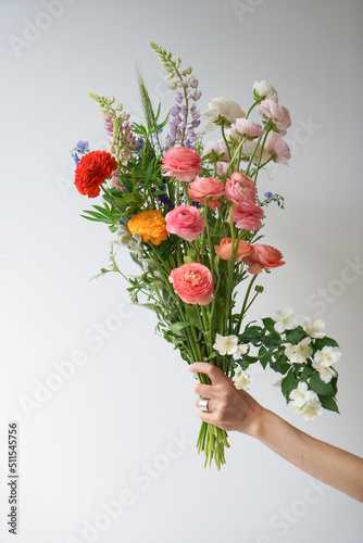 hand holding bouquet of ranunculus 
