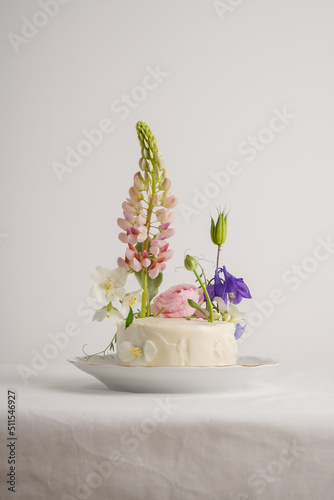 Wallpaper Mural White cake for one person, decorated with flowers with lupine and other colored flowers Torontodigital.ca