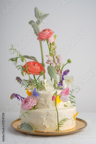 Wallpaper Mural Multilevel large white cake on a light background decorated with fresh flowers Torontodigital.ca