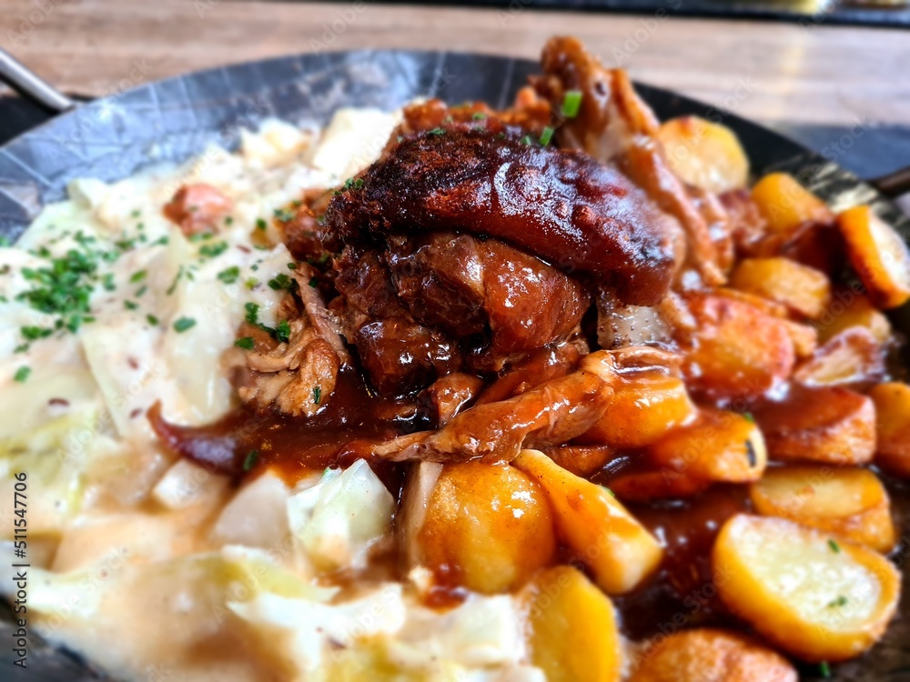 Meat of pork knuckle with malt and hop crust on sweet cream cabbage with caraway and roasted potatoes. Meat of pork knuckle with malt and hop crust on sweet cream cabbage with caraway and roasted potatoes.