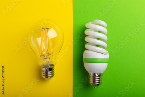 Electric light bulbs. the concept of energy efficiency. LED lamp vs incandescent lamp. Composition on yellow green background.Use economical and environmentally friendly light bulb concept.