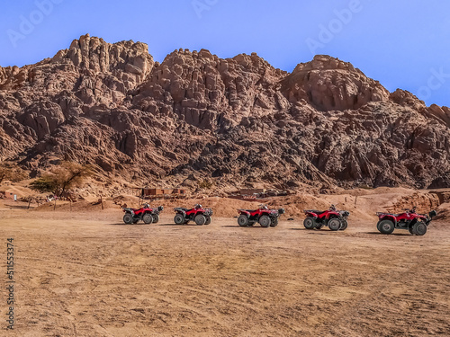 One row of ATVs in the Sinai desert against the backdrop of mountains, no people. Tourist transport in the desert near Sharm El Sheikh, Egypt photo