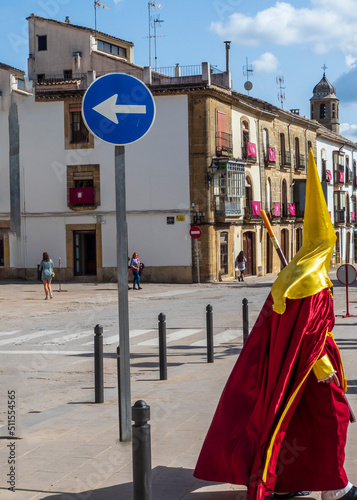 Nazareno pasando por las calles de Úbeda con la túnica y capirote tradciconal de Semana Santa photo