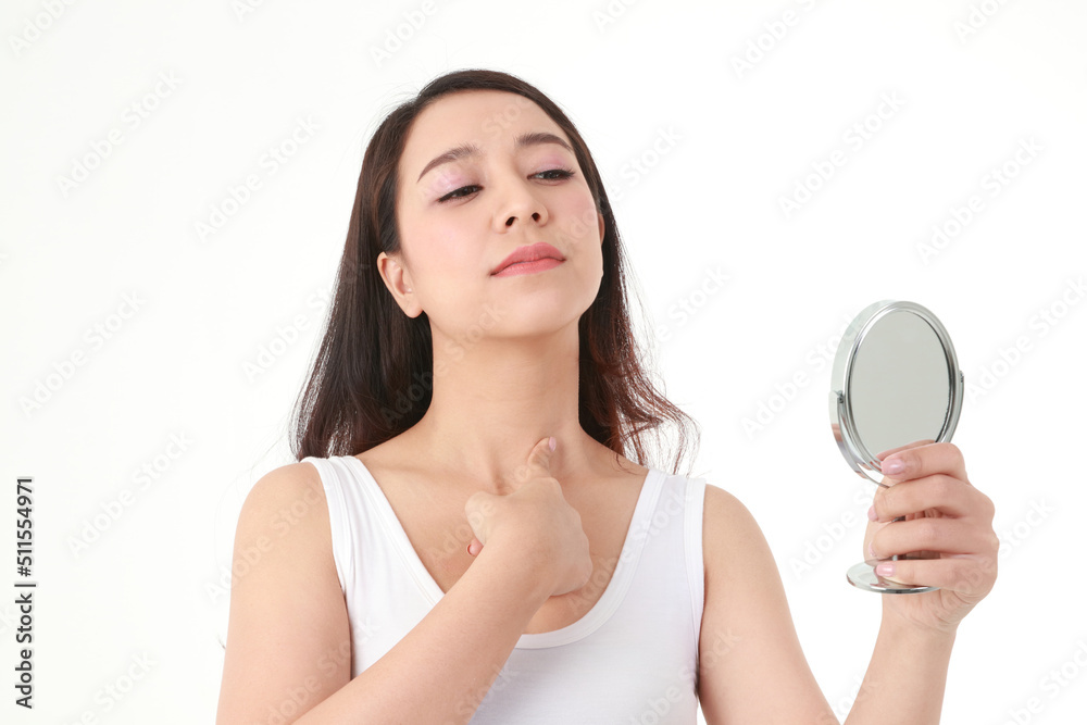 Beautiful Asian woman holding a mirror looking at acne on her neck. She was very stressed. Beauty concept, beautification, beauty skin care. white background Beautiful Asian woman holding a mirror looking at acne on her neck. She was very stressed. Beauty concept, beautification, beauty skin care. white background