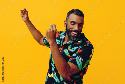 close up handsome bearded mid adult african american man smiling and dancing wearing Hawaiian shirt on vacation studio shot