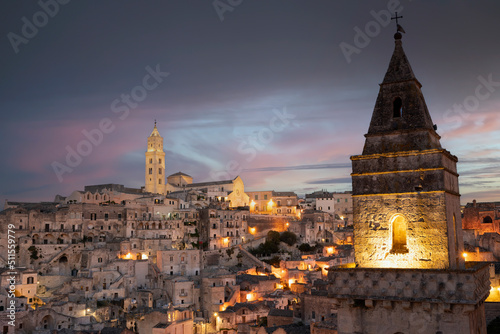 Stunning view of the illuminated village of Matera during a beautiful sunset. Matera is a city on a rocky outcrop in the region of Basilicata, in southern Italy. © Travel Wild