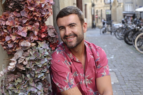 Stylish man wearing pink shirt with floral background