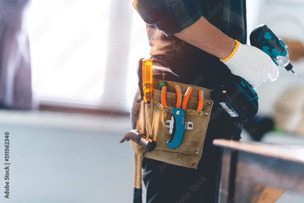 Male mechanic using a cordless screwdriver drill with wood screws in the workshop.
