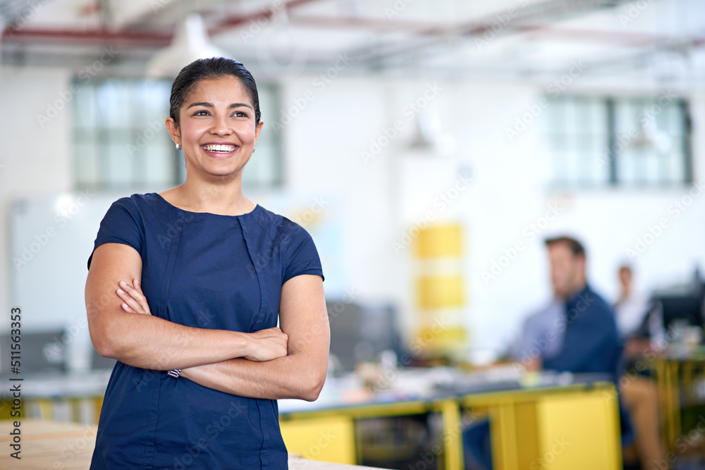 Feeling confident about the future of her company. Shot of an attractive young businesswoman standing with her arms folded in the office.