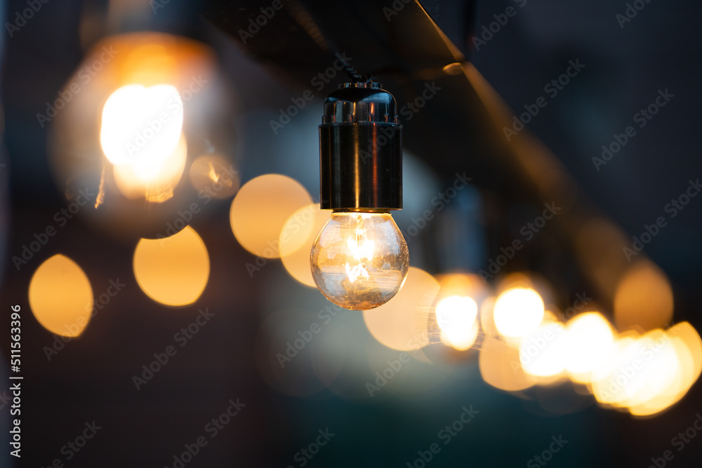 Yellow light bulb among another on wood. Bokeh background. Yellow light bulb among another on wood. Bokeh background.