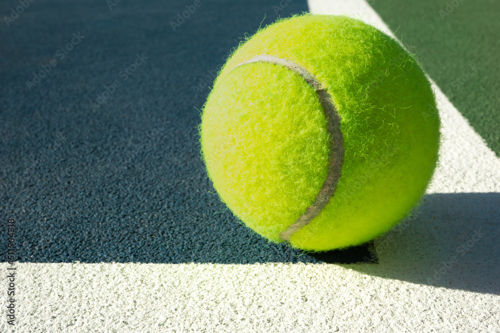 Low angle close up view of a tennis ball on the court inside lines