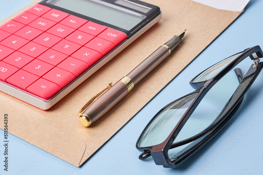 Envelope and financial documents with calculator on blue background. Close up