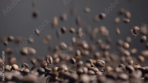 Coffee seeds dawnfall closeup. Roasted beans falling down on table bouncing. photo