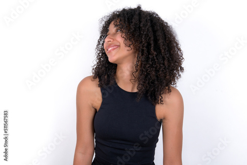 Young beautiful girl with afro hairstyle wearing black tank top over white background very happy and excited about new plans.