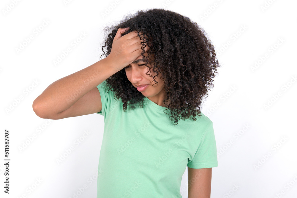 A very upset and lonely Young beautiful girl with afro hairstyle wearing green t-shirt over white background crying, A very upset and lonely Young beautiful girl with afro hairstyle wearing green t-shirt over white background crying,