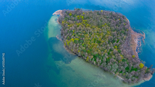 Top down view of the island in the shallow lake. Blue water and mixed trees. photo