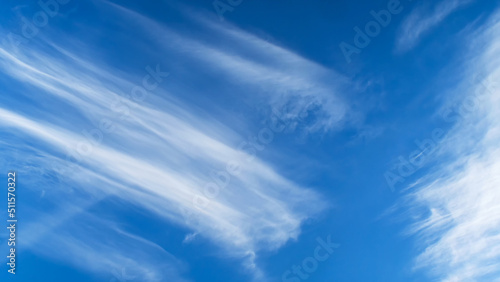 There are beautiful, unusually shaped white clouds in the blue sky.