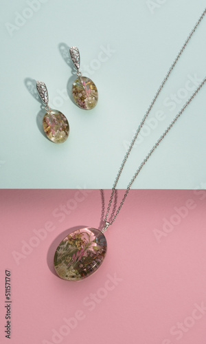Top view of bijouterie set necklace and earrings made of epoxy resin on pastel colors background photo