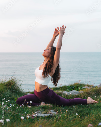 Slim woman in activewear doing yoga in nature photo