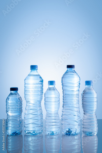 Collection of water bottles isolated on blue background with copy space. Vertical format.