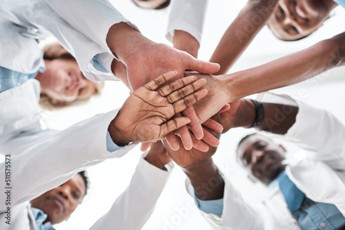 Team-based care is essential for meeting value-based care goals. Closeup shot of a group of medical practitioners joining their hands together in a huddle. photo