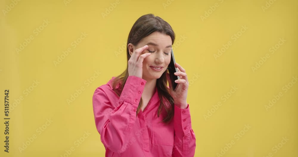 Close up portrait of happy young beautiful woman speaking on mobile phone and smiling in good mood. Female model on yellow background indoor calling on smartphone, positive emotions, communication Close up portrait of happy young beautiful woman speaking on mobile phone and smiling in good mood. Female model on yellow background indoor calling on smartphone, positive emotions, communication