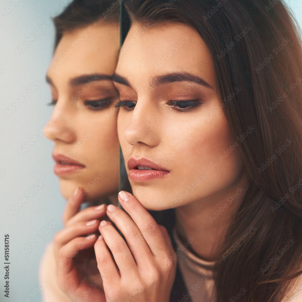 The mirror does not define your beauty. Shot of a beautiful young woman leaning against a mirror. The mirror does not define your beauty. Shot of a beautiful young woman leaning against a mirror.