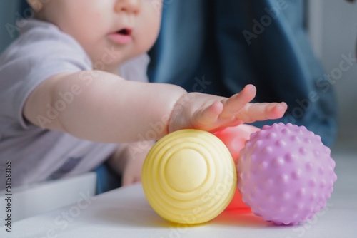 Wallpaper Mural Baby holding a colorful sensory soft ball for babies and kids. Concept of massage textured balls for developing tactile senses.  Torontodigital.ca