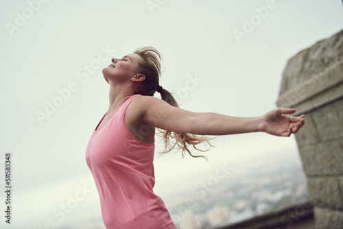 Nothing feels better than fitness. Shot of a happy young woman feeling free while out for a run in the city.