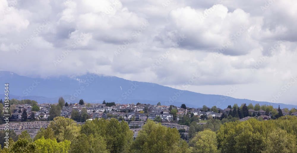 Residential homes in suburban neighborhood. Modern Cityscape. Mountain Landscape in Background. Port Coquitlam, Vancouver, BC, Canada.