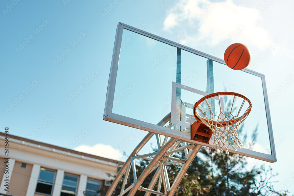 Thats going to be an airball shot. Still life shot of a basketball landing into a net on a sports court.