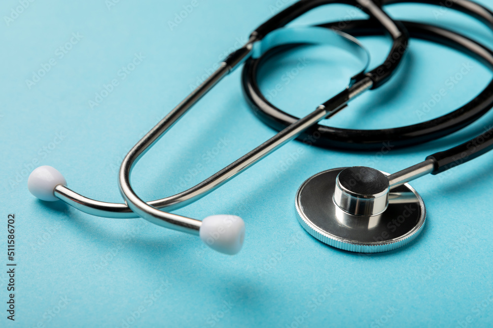 Black stethoscope on a blue background, closeup.Health care. Place for text. Medicine concept Black stethoscope on a blue background, closeup.Health care. Place for text. Medicine concept