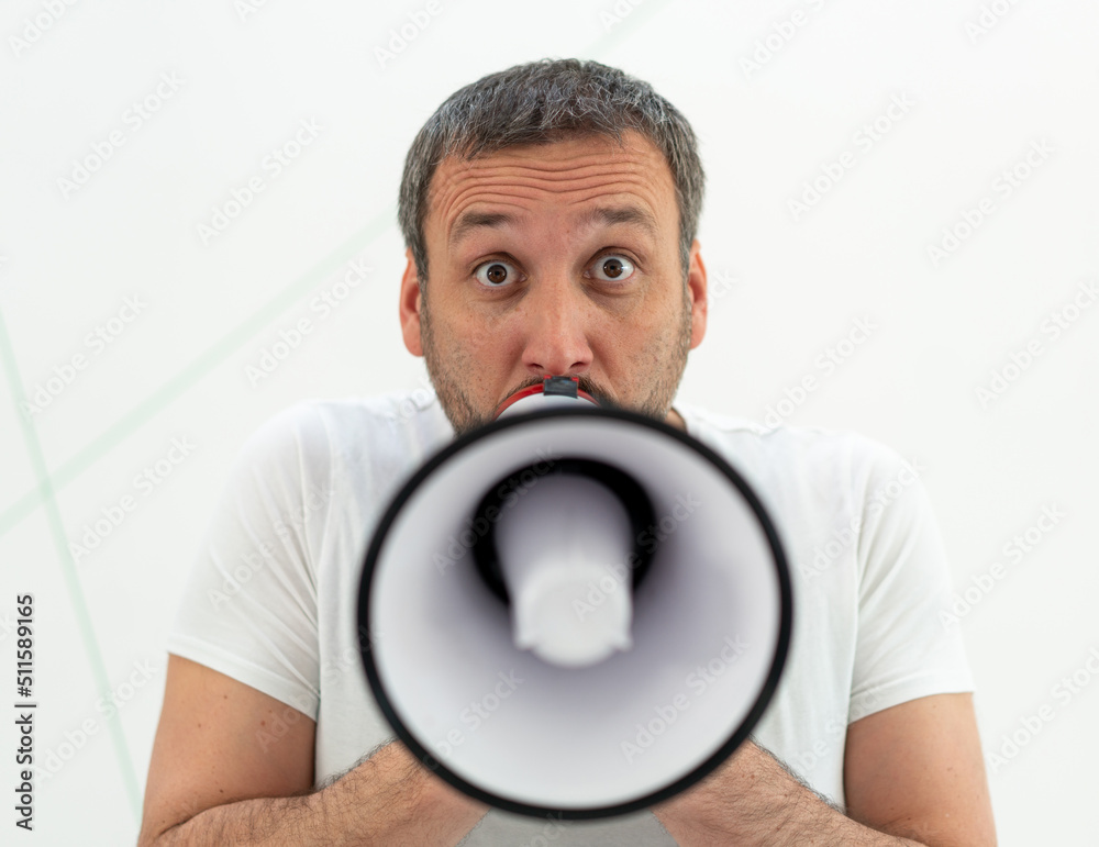 A man with beard holding white megaphone, alone A man with beard holding white megaphone, alone