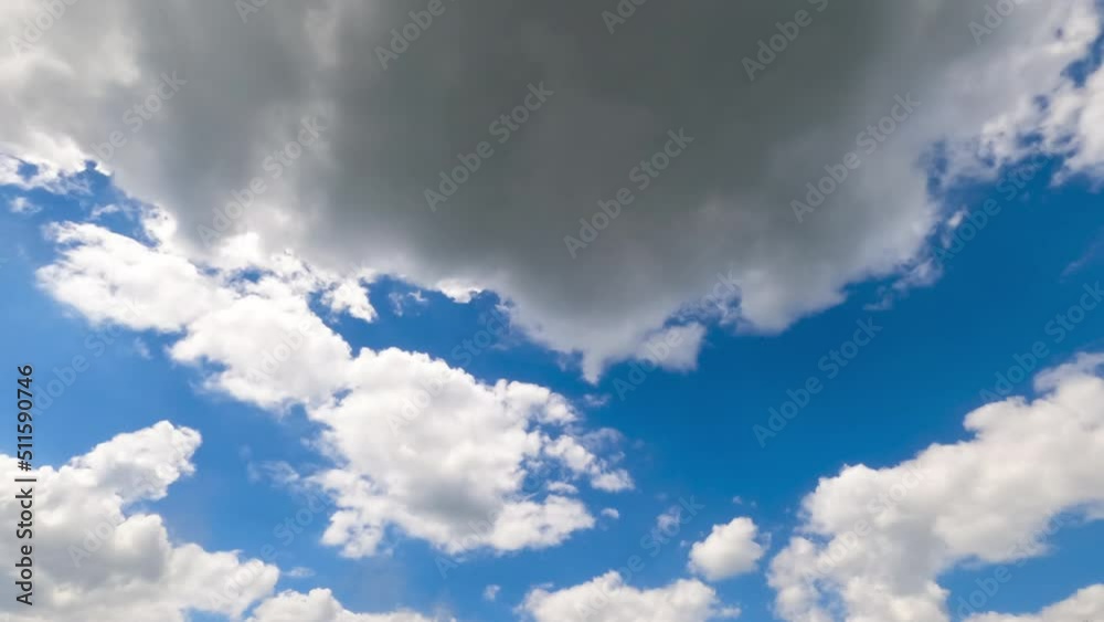 Soft puffy clouds quickly changing shape. Sun rays passing through the cloudscape. Timelapse.