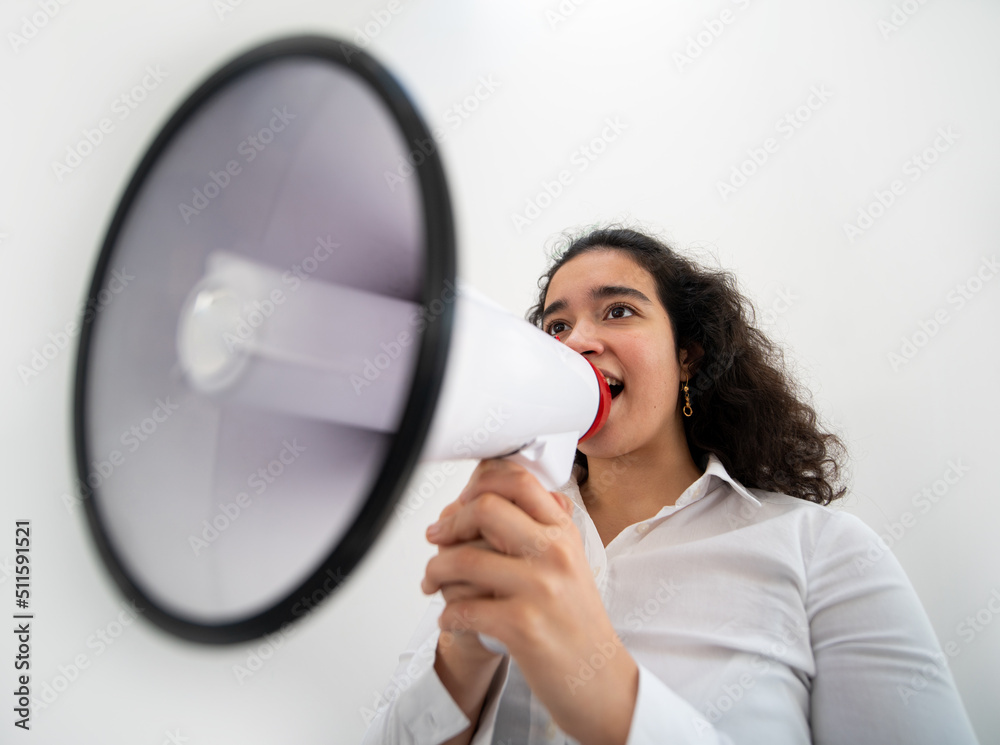 Beautiful business woman with curly hair holding a megaphone. High quality photo Beautiful business woman with curly hair holding a megaphone. High quality photo