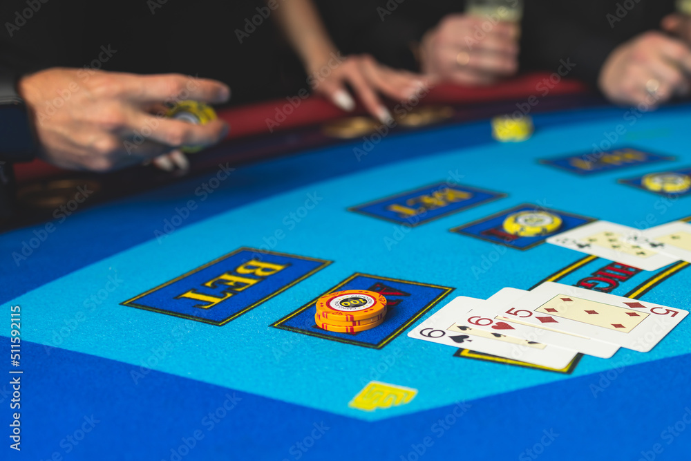 Poker table view with a pack of cards, tokens, alcohol drinks, dollar money and group of gambling rich wealthy people playing poker in casino, with croupier Poker table view with a pack of cards, tokens, alcohol drinks, dollar money and group of gambling rich wealthy people playing poker in casino, with croupier