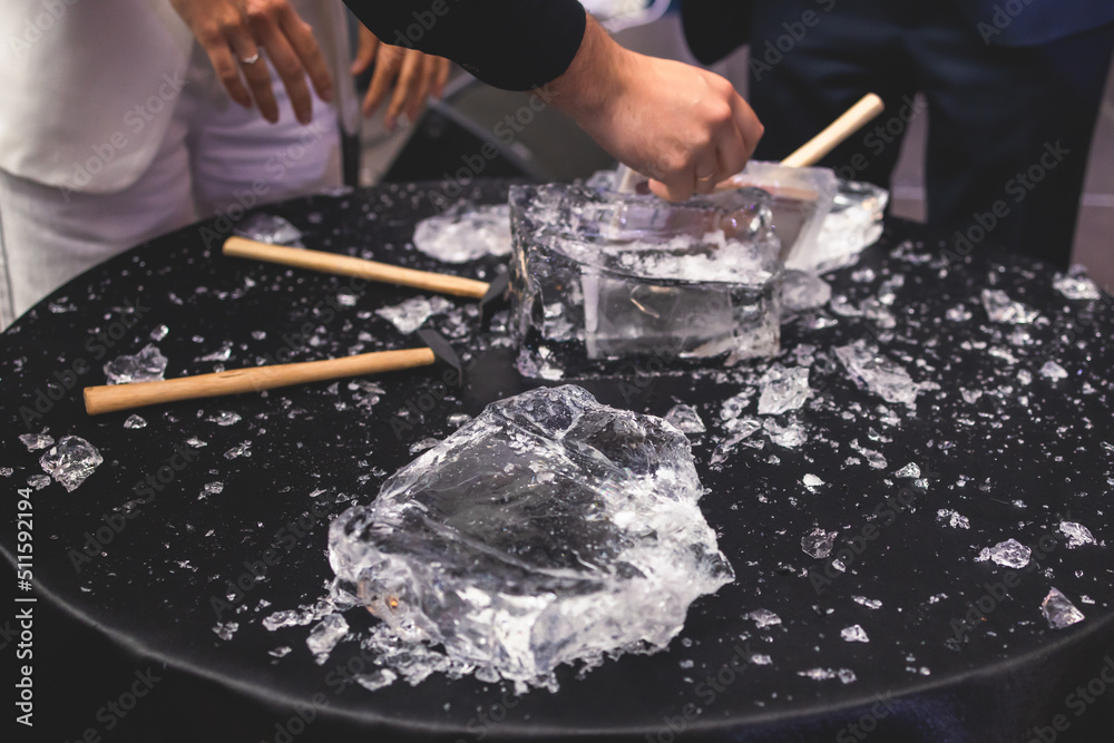 Process of breaking the ice with hammer and ice pick, group of people